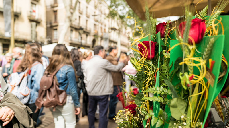  People walking down la Rambla with a stand of roses in the foreground