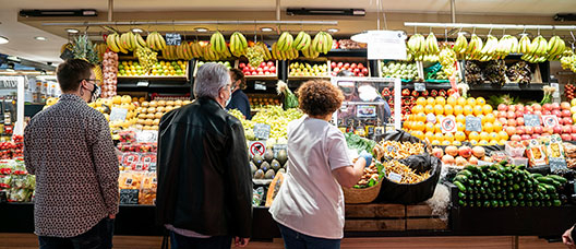 Gente comprando en una parada de frutas y verduras del Mercado del Ninot