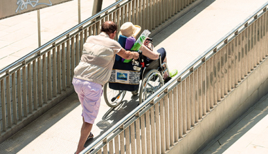 Un hombre empuja una silla de ruedas en una rampa de acceso a la playa