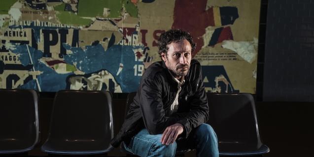 El actor protagonista sentado en un banco y mirando a la cámara