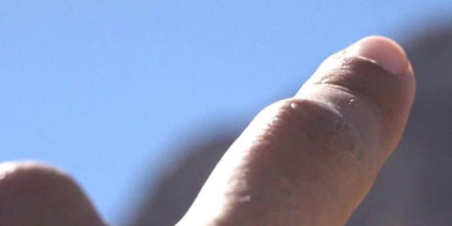 La fotografía de un dedo que señala en una de las obras que forman parte de la exposición