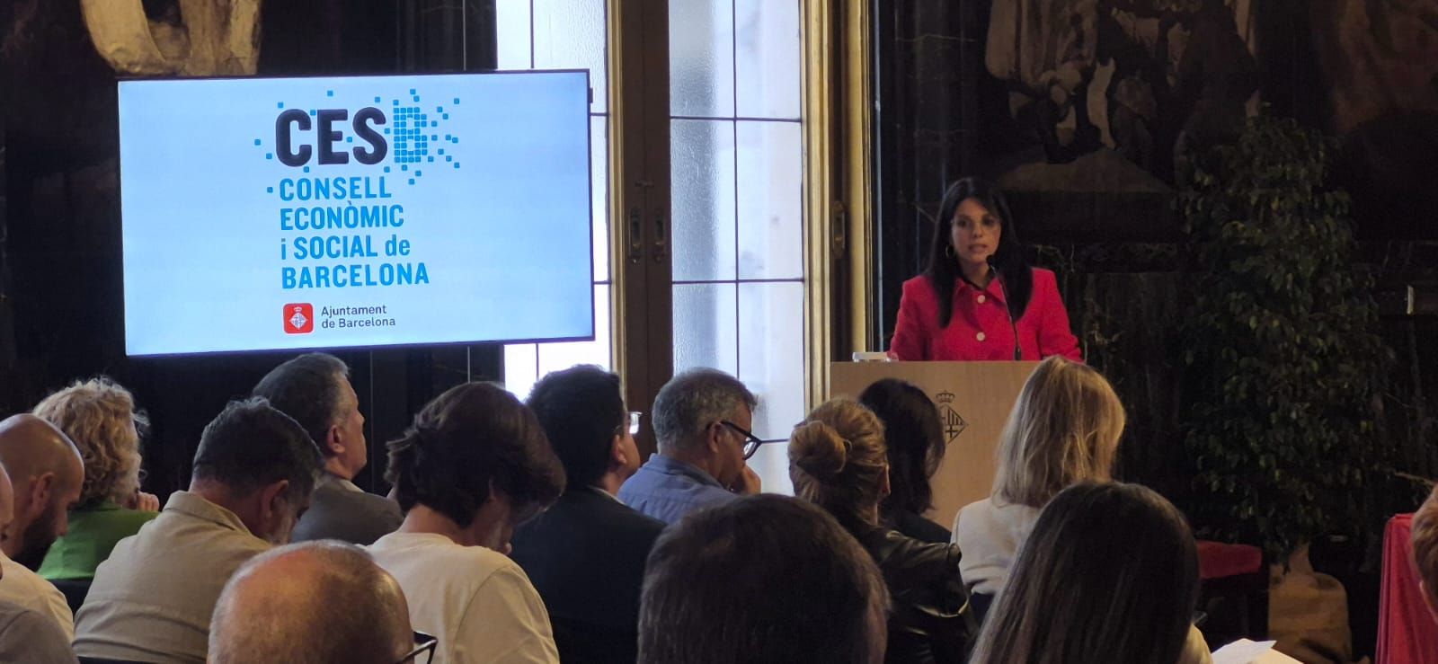 Vista del públic i la taula presidencial al fons. Intervenció de Liliana Reyes, representant de CCOO.