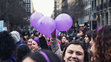 Young women at an 8 March demonstration with purple coloured balloons 