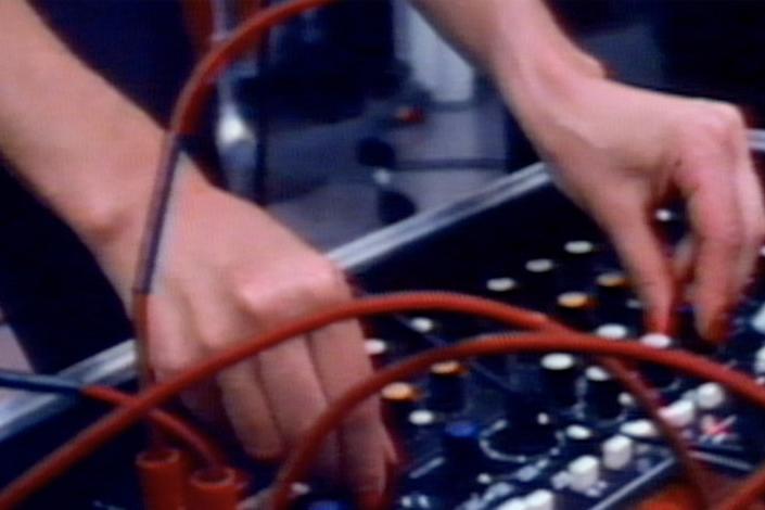Unes mans punxant música electrònica, imatge de l'exposició PIONERES [D]’ones i experimentació sonora