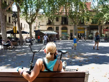 Noia asseguda a un banc