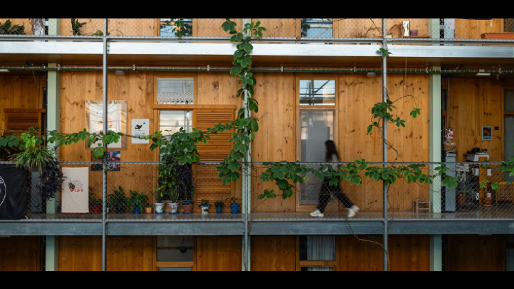 Una noia caminant per un passadís interior de l’habitatge cooperatiu La Borda (Autor: Lucas Amillano)