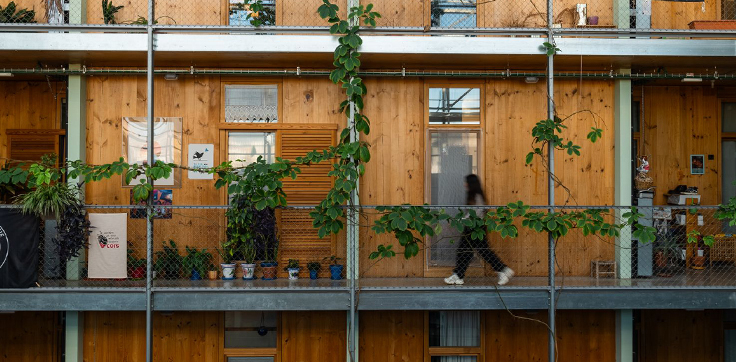 Una noia caminant per un passadís interior de l’habitatge cooperatiu La Borda (Autor: Lucas Amillano)