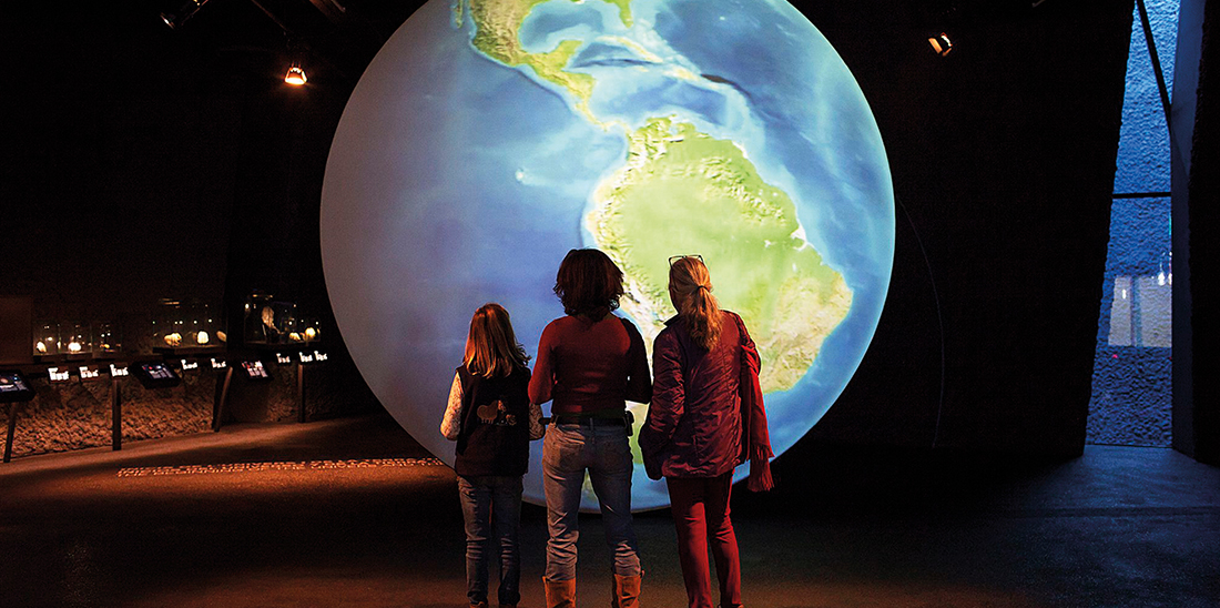 Visitants del Museu Blau mirant un globus terraqüi.