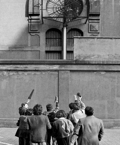Un grup de periodistes entrevisten Juan José Moreno Cuenca, el Vaquilla, que apareix a la finestra de la presó Model de Barcelona, el 13 d’abril de 1984. El famós delinqüent liderava un motí amb ostatges. © Pepe Encinas