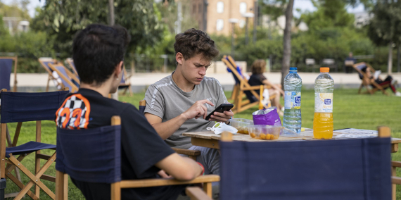 Dos joves conversen mentre mengen en una de les taules disponibles a la Clariana de les Glòries.  © Imatges Barcelona / Àlex Losada