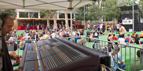 Tècnic ajustant els nivells d'una taula de so en una sessió a l'aire lliure del Festival Sònar