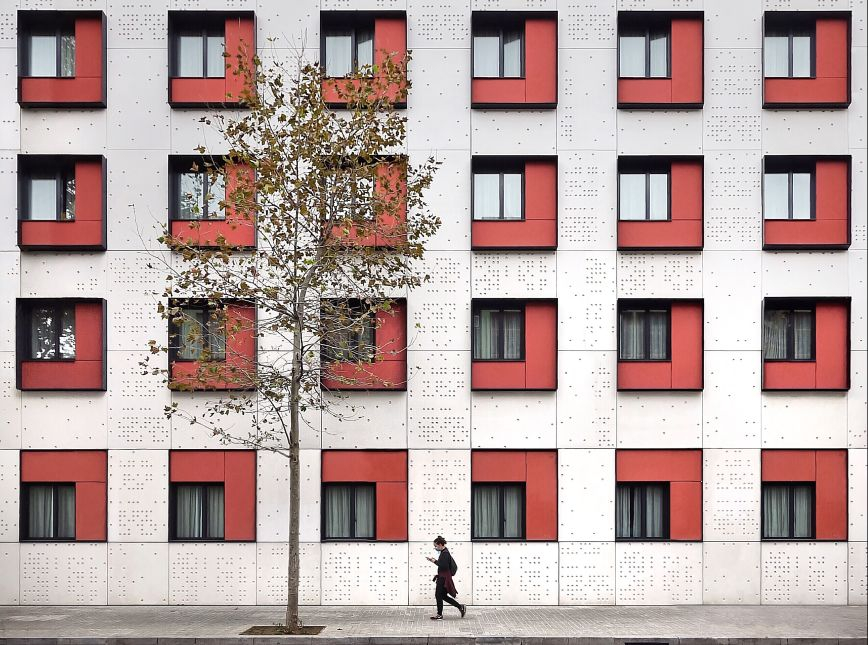 © Roc Isern Una dona passa davant les façanes geomètriques dels set pisos d'un hotel. 
