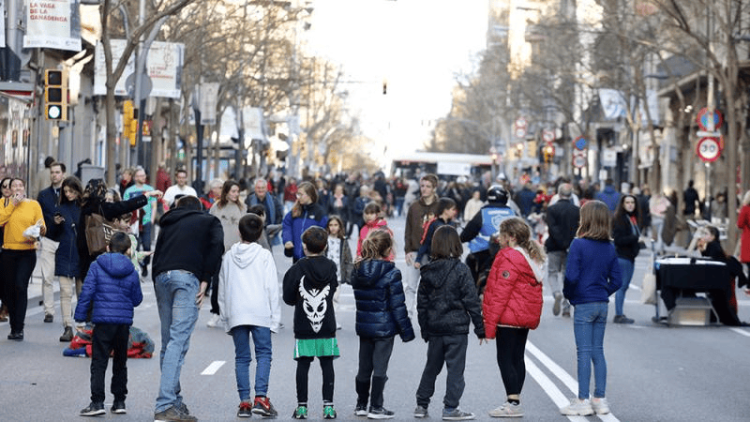 Un grup de nens i famílies omplen el carrer en una jornada lúdica a l’aire lliure.