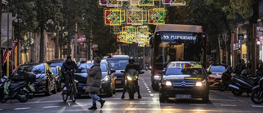 Vehicles stopped in front of a traffic light under the Christmas lights of Carrer Fontanella