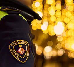 A Guardia Urbana oficer patrols a street in Barcelona illuminated with Christmas motifs.