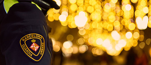 La Guardia Urbana patrulla por una calle de Barcelona iluminada con motivos navideños.
