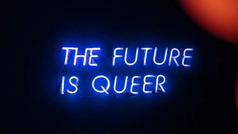 Neon lights reading “The future is queer” on the stage at the Candy Darling Bar