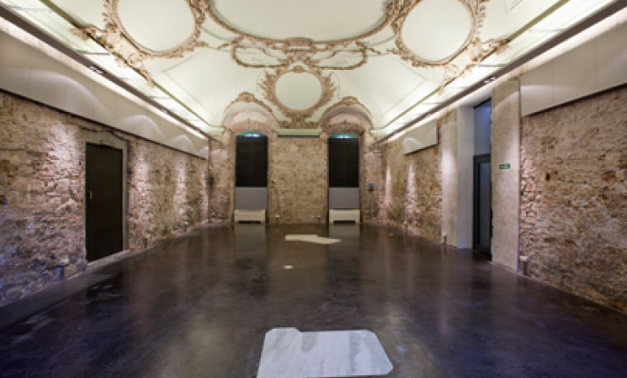 Vista interior del Centre Cívic Convent de Sant Agustí, amb parets de pedra vista i sostre il·luminat