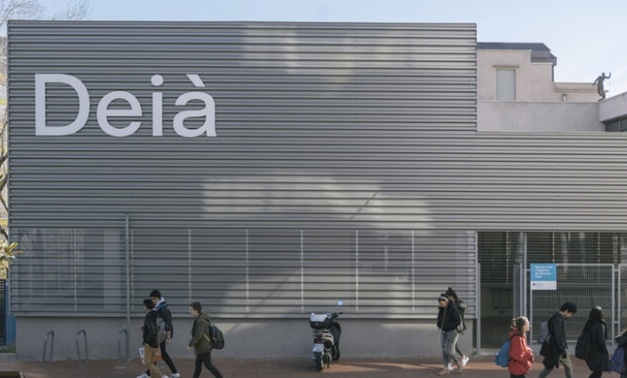 Vista exterior de l'Escola d'Art i Disseny Deià, amb alumnes caminant pel davant.