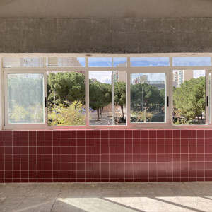 Imagen del interior de un espacio en Bellvitge, con una ventana que da al exterior, donde se ven árboles