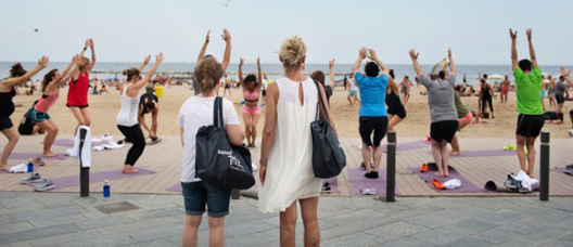 Mujeres haciendo yoga delante de la playa 