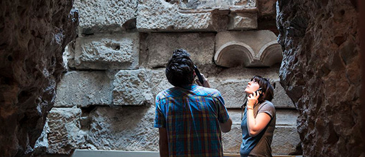 Una pareja visita las murallas romanas de Barcelona