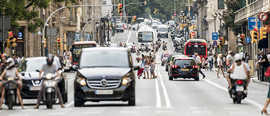 Vehículos circulan por una calle de Barcelona