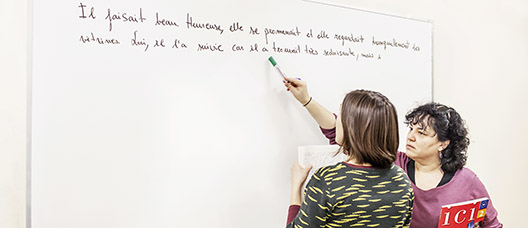Profesora y alumna en la pizarra en una clase de francés 