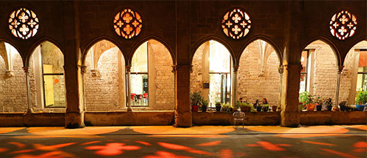 Pati del convent de Sant Agustí de nit il·luminat amb llums vermelles
