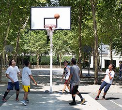 A group of youngsters play basketball in a park 
