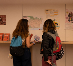 Noies llegint un díptic en un punt d'informació juvenil