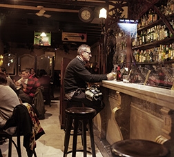 Man sitting at the bar of a restaurant having a drink  