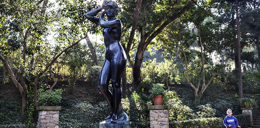 Estàtua d'una dona al parc de Laribal mentre un nen corre al voltant