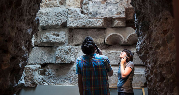 Una pareja visita los restos de la muralla romana en el Museo de Historia de Barcelona