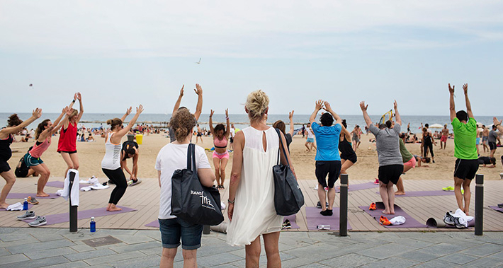 Mujeres haciendo yoga delante de la playa